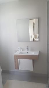 uma casa de banho branca com um lavatório e um espelho em Margie's Place em Swellendam