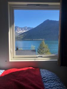 a bedroom window with a view of a lake at Vacation Home in Fjordgård with views of Segla and the Fjord in Fjordgård