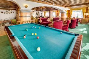 una sala biliardo con tavolo da biliardo in una casa di Parc Hotel Victoria a Cortina dʼAmpezzo