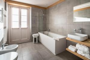 La salle de bains est pourvue d'une baignoire, d'un lavabo et de toilettes. dans l'établissement Parc Hotel Victoria, à Cortina dʼAmpezzo