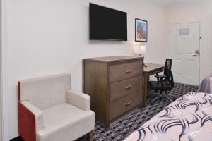 a hotel room with a desk and a chair at Americas Inn & Suites IAH North in Humble