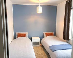 1 dormitorio con 2 camas y pared azul en Vacation Home in Fjordgård with views of Segla and the Fjord, en Fjordgård