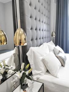 a bedroom with a white bed with a large headboard at MINT Boutique Studio Apartments in Zagreb