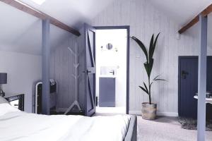 a bedroom with a bed and a potted plant at Highfield Barn Loft in Portishead