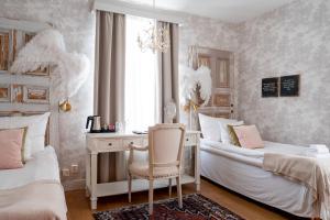 um quarto com 2 camas, uma secretária e uma cadeira em Karstorp Säteri – Hotell och Konferens em Skövde