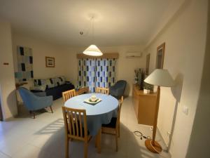 une cuisine et un salon avec une table et des chaises dans l'établissement Apartamento T1 Quinta Nova - Alvor, à Alvor