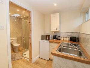 Una pequeña cocina con fregadero y refrigerador. en Jacob’s Ally, en Knaresborough