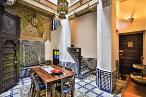 a room with a table and chairs and a staircase at Dar Chez Khadija in Fez