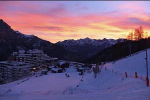 - une piste de ski avec des personnes au coucher du soleil dans l'établissement Puy Saint Vincent 1700, à Puy-Saint-Vincent
