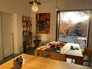 a dining room with a table and a large window at La maison de Mado et sa cabane dans les arbres in Plan dʼAups