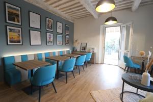a dining room with tables and blue chairs at Botrona B&B in Scarlino