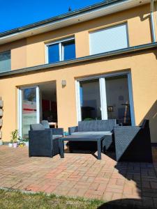 a patio with a table and chairs in front of a building at Tolle Wohnung in Fontanestadt Neuruppin in Neuruppin