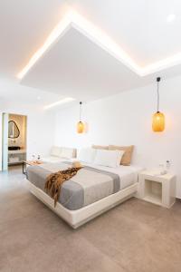 a white bedroom with a large bed in a room at Caldera Cliff Illusion in Fira