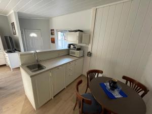 a kitchen with a table and a sink and a table and chairs at Schöner Ferienbungalow umgeben von Natur und nicht weit zur Ostsee in Neubukow