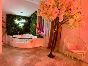 baño con bañera y árbol en Romantica Spa en Saint Die