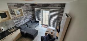 ein Wohnzimmer mit einem Sofa und einer Steinmauer in der Unterkunft 't Hagerhuys in Maaseik