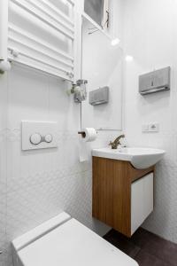 Baño blanco con lavabo y aseo en Origine Rentals Galata L1, en Estambul