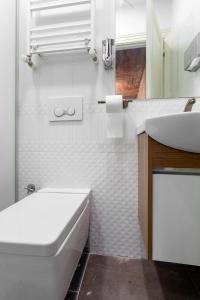 Baño blanco con lavabo y bañera en Origine Rentals Galata L1, en Estambul