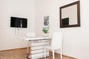 einen weißen Schreibtisch mit einem Laptop und einem Spiegel in der Unterkunft Big Apt in Viennas Center - Perfect for Longstays in Wien