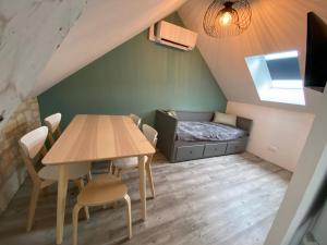 una pequeña habitación con una mesa y una cama en Logement Loire climatisé, La Halte de Cuze, aux abords de la Loire a vélo, en Huismes