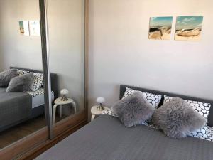 a bedroom with a mirror and a bed with pillows at Nadmorski Apartament Dream w Gdańsku in Gdańsk