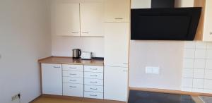 a small kitchen with white cabinets and a microwave at Monteurswohnung Tim in Zweibrücken +12 photos