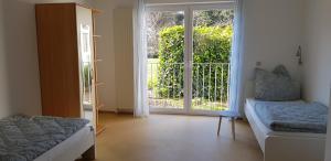 a room with two beds and a sliding glass door at Monteurswohnung Tim in Zweibrücken