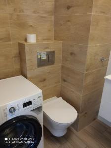 a bathroom with a toilet and a washing machine at Nadmorski Apartament Dream w Gdańsku in Gdańsk