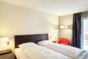 a hotel room with two beds and two lamps at Tivoli Hotel Innsbruck in Innsbruck