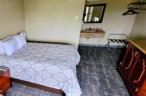 a bedroom with a bed and a bathroom with a sink at Queen City Inn in Bangor