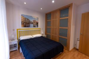 a bedroom with a bed with a blue comforter at Herradores Centro in Soria