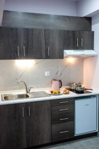 a kitchen with wooden cabinets and a sink at Studio Elena in Néa Péramos