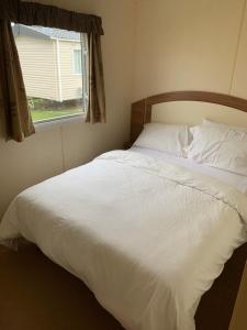 A bed or beds in a room at Cosy Private Caravan Romney Sands Holiday Park