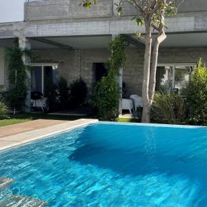 een blauw zwembad voor een huis bij Loft incantevole con piscina in Tortolì