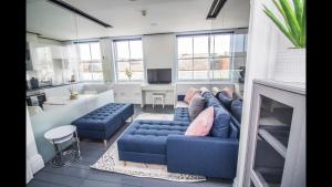 a living room with a blue couch and a fireplace at Luxury Penthouse in listed building in Newcastle upon Tyne