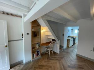 an attic hallway with white walls and wooden floors at Peaceful period cottage in central location in Penzance
