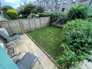 a small backyard with a fence and a yard with chairs at Peaceful period cottage in central location in Penzance