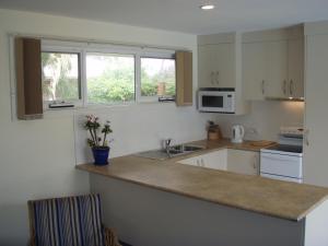 a kitchen with white cabinets and a counter top at Bambra Reef Lodge in Sandford