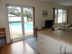 a kitchen with a view of a swimming pool at Bambra Reef Lodge in Sandford