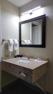 a bathroom with a sink and a mirror at Queen City Inn in Bangor