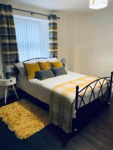 a bedroom with a bed with yellow and blue pillows at Little Bere apartment in Lifton