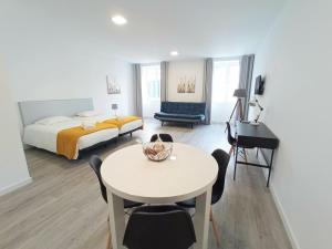 um quarto de hotel com uma cama, uma mesa e uma secretária em Tanoeiros Studios no Funchal