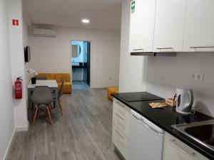 eine Küche und ein Wohnzimmer mit einem Tisch und einer Theke in der Unterkunft Tanoeiros Studios in Funchal
