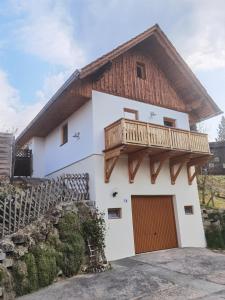 une maison avec un toit en bois et un balcon dans l'établissement Ferienhaus Kranach 76, à Gamlitz