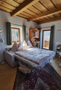 a bedroom with a bed and a couch and windows at Ferienhaus Kranach 76 in Gamlitz