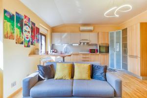 ein Wohnzimmer mit einer blauen Couch in einer Küche in der Unterkunft Frida apartment nuovo luminoso con vista aperta in Triest