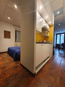 una camera con un letto e una cucina di Appartamento vacanze al lago Orta San Giulio a Orta San Giulio