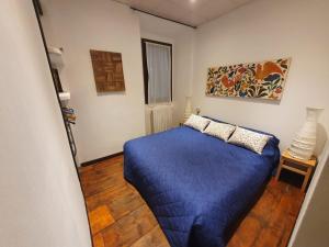 una camera da letto con un letto blu in una stanza di Appartamento vacanze al lago Orta San Giulio a Orta San Giulio