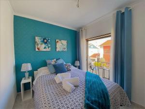 a blue bedroom with a bed and a window at Private Villa 4 BR&patio - 3 mins from Beach&Surf in Baleal