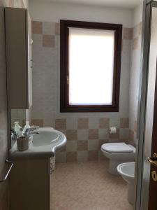 baño con lavabo y aseo y ventana en HOME NUOVA OSTIGLIA, en Padernello